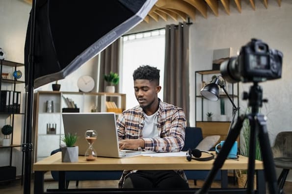 Video marketer working on a laptop at a desk.