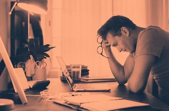 person at desk with meeting fatigue