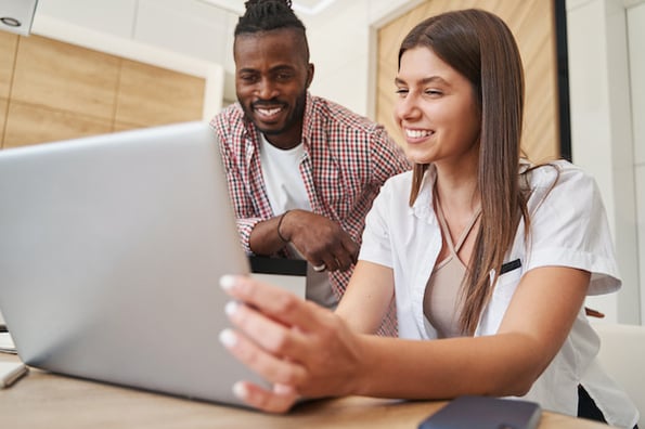 two people viewing microsite examples on a laptop