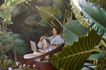 Person looking at natural websites on their phone while surrounded by nature 