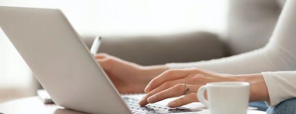 close-up of hands typing on a laptop