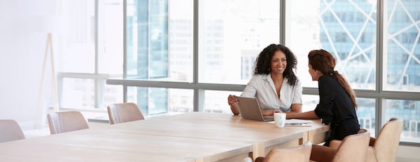 two people talking in a conference room