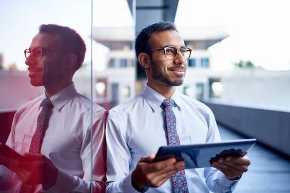 real estate broker smiling and holding tablet