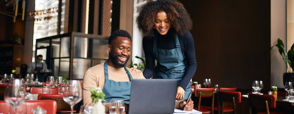 two restaurant owners using a laptop