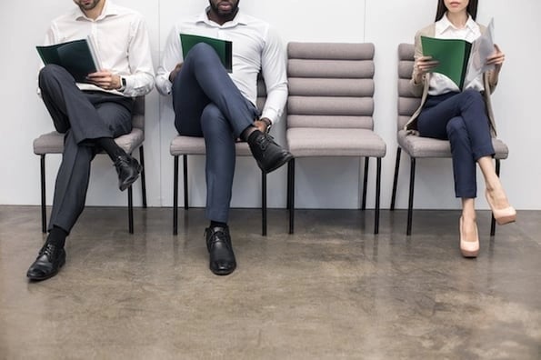 person sitting in office waiting for interview with resume templates in hand