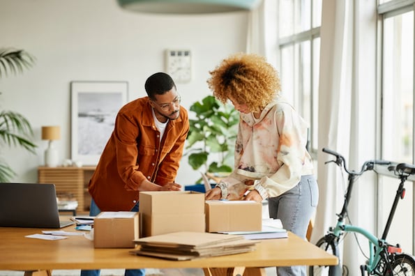 small business owners packing up product to send to new customers. 