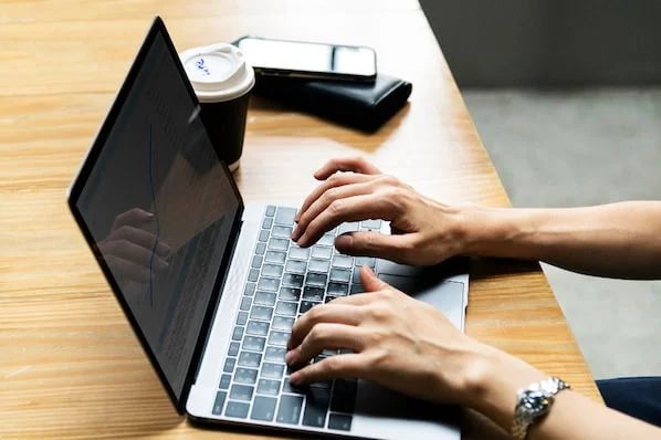 hands typing on laptop taking screenshot on a mac