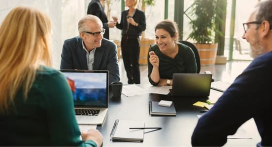 group of people at table with laptops during a technical demo