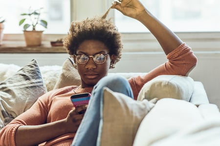 Woman reading about TikTok's keystroke & keyboard monitoring controversy and deciding whether or not to delete the app