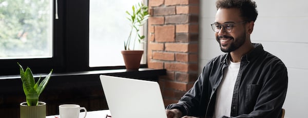 man using a computer and smiling