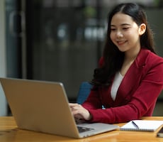 person using a laptop and a notepad