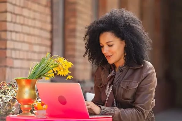 woman using a laptop to learn the difference between web services vs apis