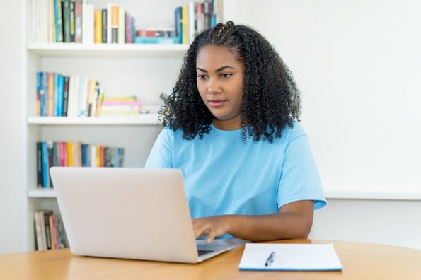 Young woman studying what JavaScript is, how to use it, and industries it can be found in.