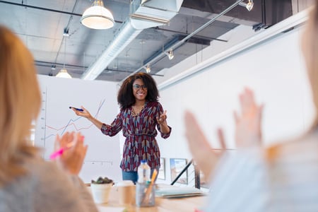 woman presenting in a meeting and showcasing her leadership skills