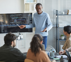 person showing code to a group of developers