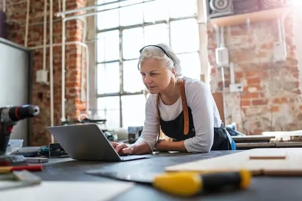 person using a laptop computer in a workshop to download a WordPress responsive table plugin 