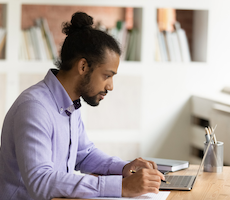 man using a laptop at a desk