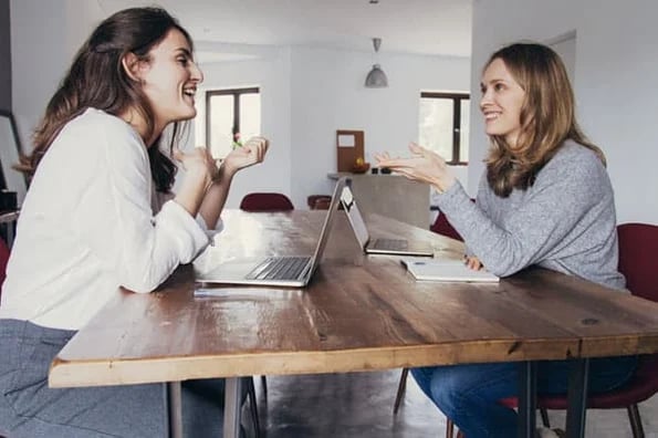 Two professionals navigate while working remotely with roommates or family.