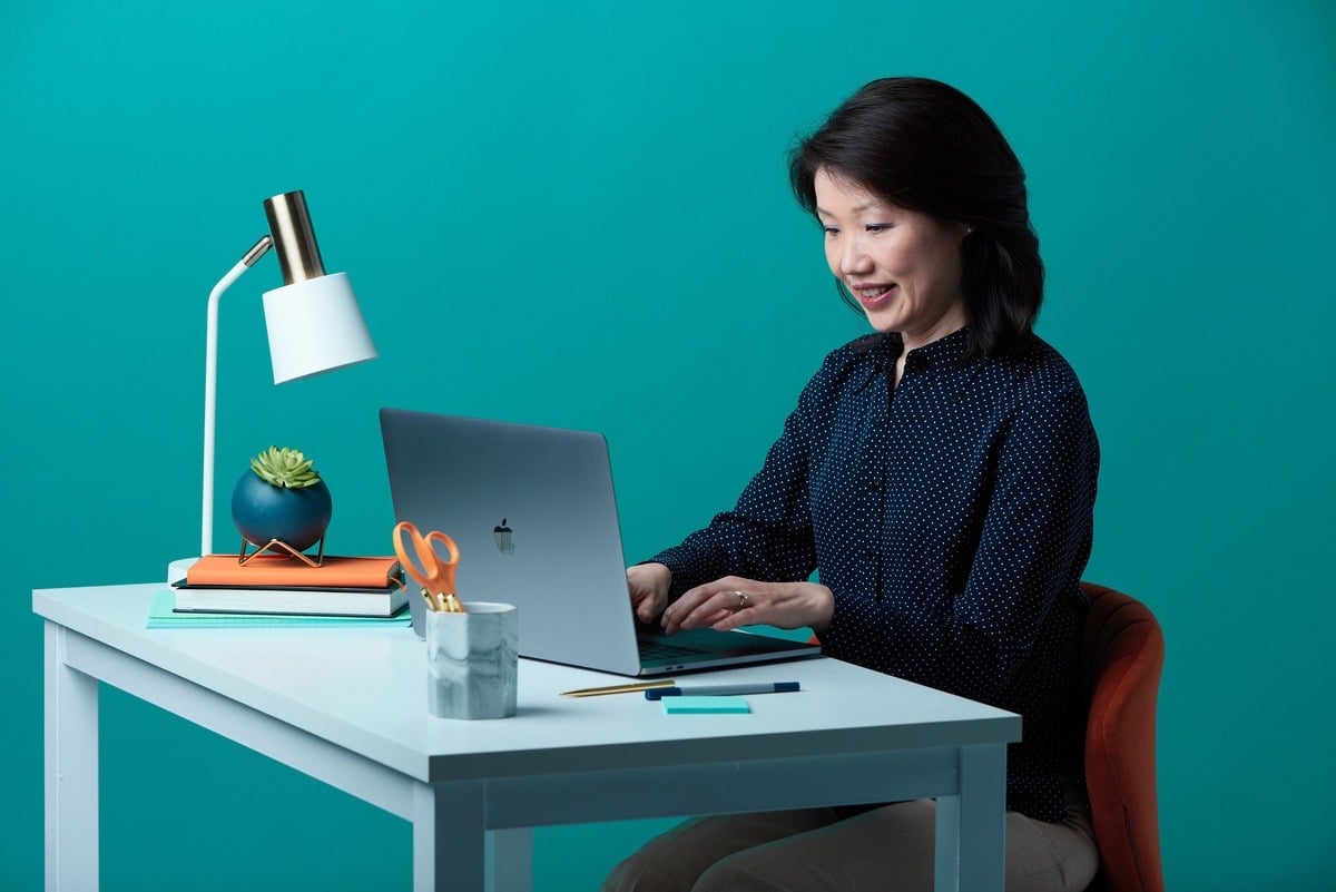 woman sitting at computer with laptop